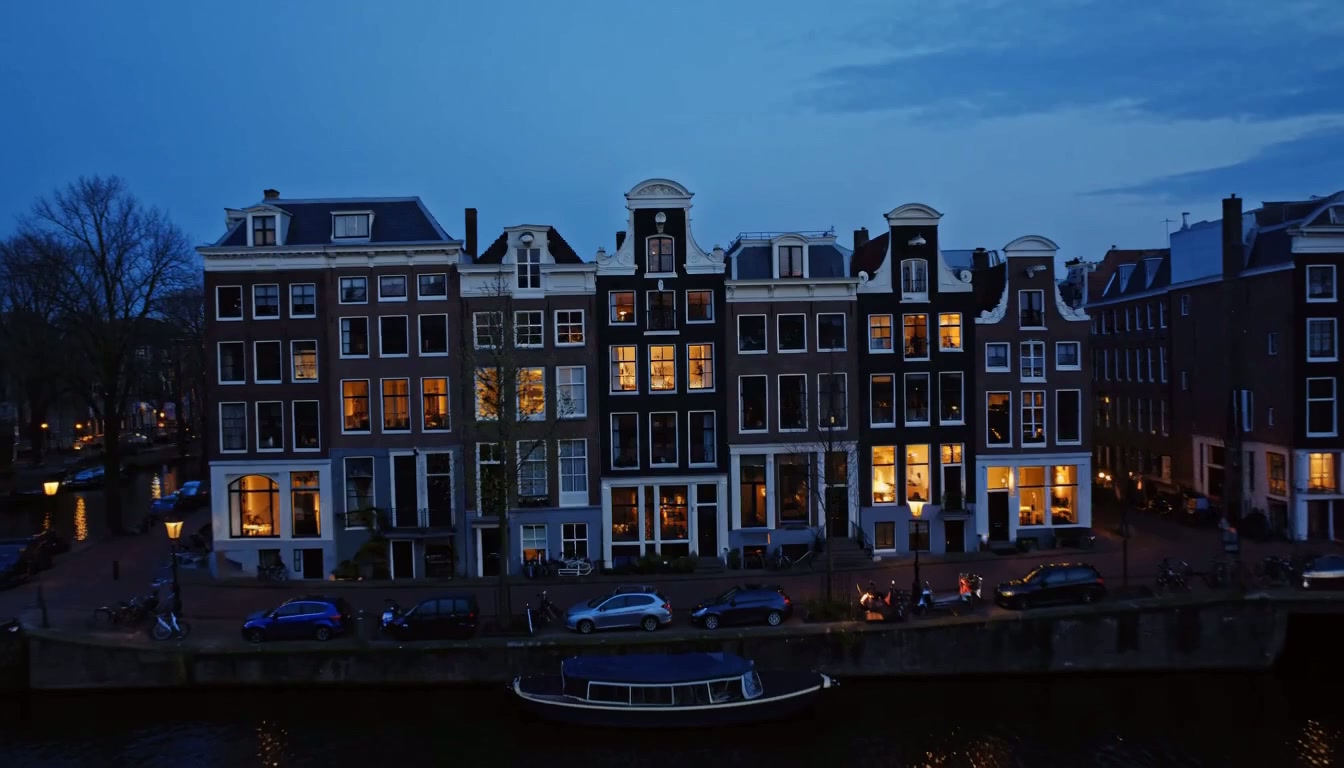 Amsterdamse grachten in de avond met warm verlichte ramen